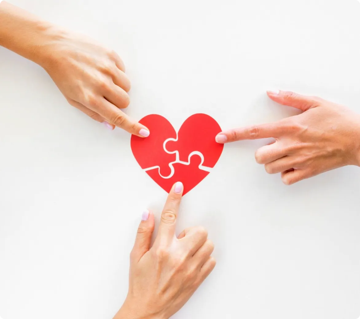 Manos uniendo las piezas de un corazón